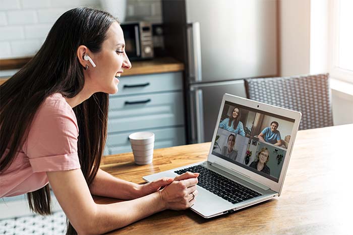A girl is using zoom app for distance video communication with coworkers, friends. People profiles on laptop desktop. Online meeting, webinars